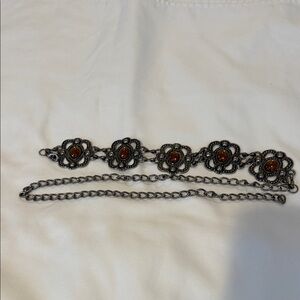 Gothic the style silver tone metal belt with orange accents.